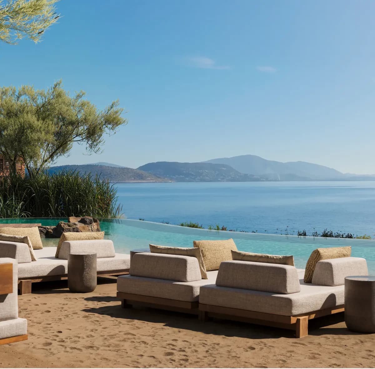 The Cabanas daybeds on the sand beside an infinity pool and sea